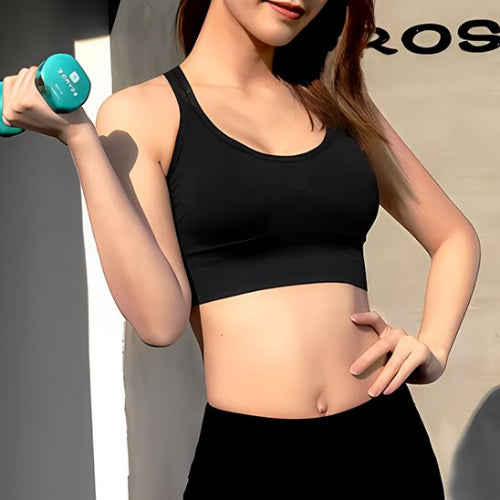 Brassières sport femme noir femme avec une haltère dans une main bras levé yoga zenitude